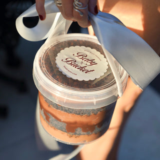 Person holding a container labeled 'Baby Bucket' with a spoon
